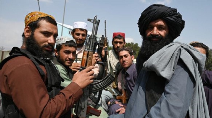 Los combatientes talibanes se sientan en la parte trasera de una camioneta en el aeropuerto de Kabul