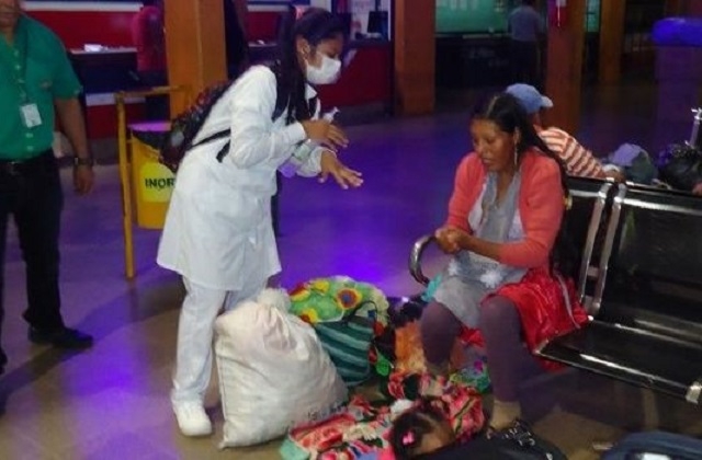 Funcionarios enseñan a los viajeros a usar alcohol en gel para prevenir la influenza. Foto: El Deber