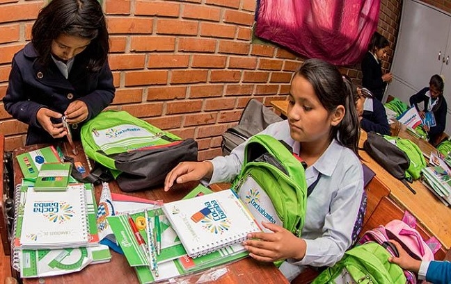 Dos estudiantes muestran los materiales escolares de la mochila que entrega el municipio. Foto: RRSS
