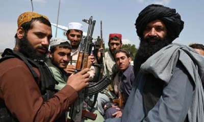 Los combatientes talibanes se sientan en la parte trasera de una camioneta en el aeropuerto de Kabul