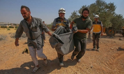 Los miembros de la Defensa Civil Siria (Cascos Blancos) se llevan a una víctima en una manta después de un ataque aéreo del régimen. 