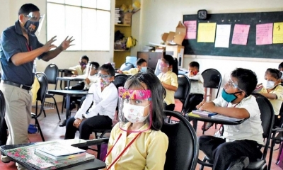 Un grupo de escolares pasa clases con medidas de bioseguridad debido al brote de COVID. 