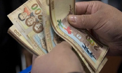 Una persona cuenta dinero tras una transacción. 