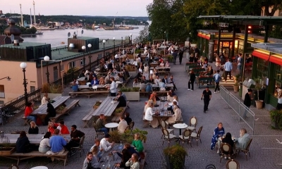 Gente en las mesas de un bar al aire libre en Estocolmo, Suecia.