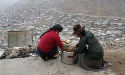 Mujeres pelan papas para la olla común en un cerro de la Nueva Rinconada, en Pamplona
