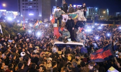 Los iraníes se reúnen alrededor de un vehículo que transportaba los ataúdes del comandante militar asesinado Qasem Soleimani. 