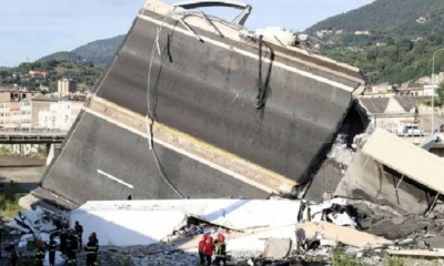 Bomberos y personal de rescate, junto a los restos del puente caído de Génova. 