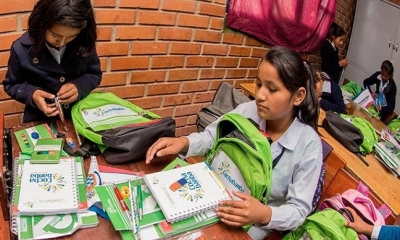 Dos estudiantes muestran los materiales escolares de la mochila que entrega el municipio. Foto: RRSS