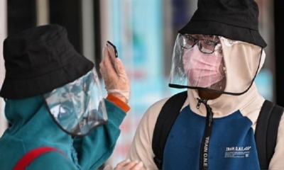 Una pareja en la estación de tren de Wuhan, la ciudad china donde se inició el coronavirus. | Fuente: AFP | Fotógrafo: Héctor Retamal