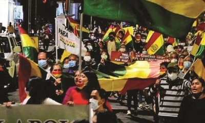 Activistas sostienen banderas y carteles anoche en la marcha. 