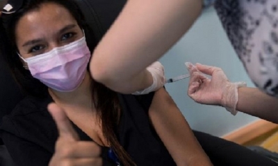 Una trabajadora sanitaria al recibir la vacuna contra la covid-19, en el Hospital de Santiago de Chile | Fuente: EFE