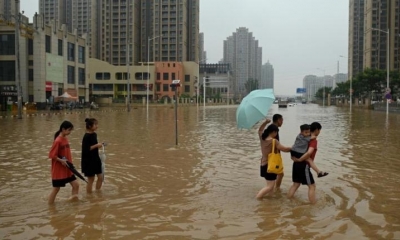 La gente camina por una calle inundada luego de las fuertes lluvias que causaron inundaciones. | AFP