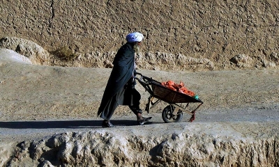 Un hombre empuja una carretilla a lo largo de un camino en Kandahar, Afganistán
