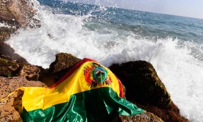 Imagen referencial de una bandera boliviana junto al mar.