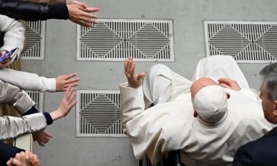 El papa Francisco, sentado en silla de ruedas, saluda a los fieles durante su audiencia general semanal en el Aula Pablo VI, ciudad del Vaticano.