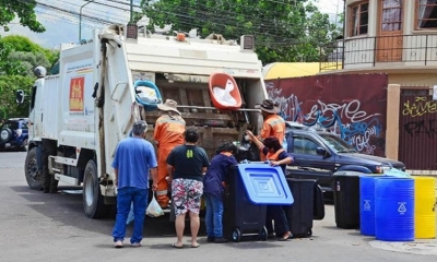 Vecinos entregan sus residuos sólidos a un carro recolector de EMSA.