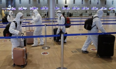 Pasajeros con trajes protectores completos y máscaras para protegerse contra la pandemia, cerca de la ciudad israelí de Tel Aviv. | Foto archivo