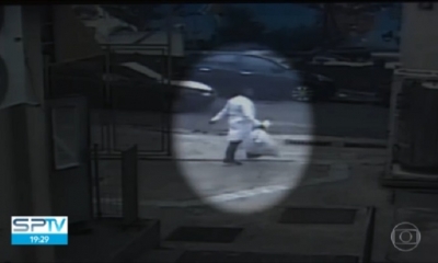 Captura del momento en el que uno de los ladrones sale disfrazado con una bata blanca cargando una bolsa de medicamentos robados.