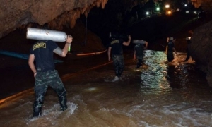 Los rescatistas transportan los tubos de oxígeno para las tareas. Foto: AFP