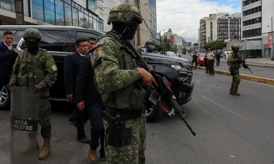 Militares custodian el vehículo que transporta al presidente de Ecuador, Daniel Noboa, a su salida de una estación de radio 