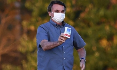 Jair Bolsonaro muestra una caja de hidroxicloroquina en los jardines del Palacio de la Alvorada, el jueves. | EFE