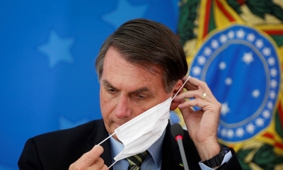 Jair Bolsonaro ajusta su tapabocas mientras anuncia medidas por coronavirus. 18 de marzo de 2020.