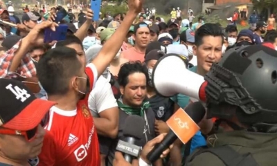 El jefe policial habla mediante el megáfono con los vecinos del Plan 3000.
