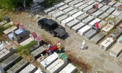 Vista aérea de trabajadores enterrando un ataúd en el cementerio de Maria Canals en las afueras de Guayaquil. | AFP