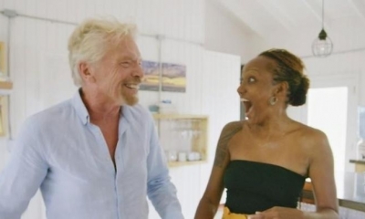 El fundador de Virgin Galactic, Richard Branson (izquierda), sorprende a la ganadora del sorteo de viajes espaciales Keisha Schahaff