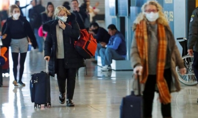 Viajeros protegidos con mascarillas este jueves en el aeropuerto Madrid-Barajas. | EFE