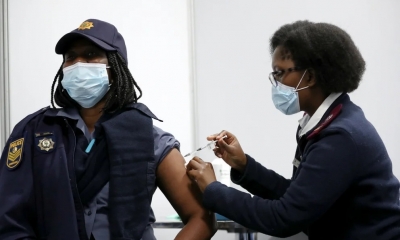 Una agente policial de Sudáfrica recibe una dosis de la vacuna contra el COVID-19 