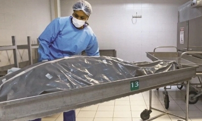 Empleado de una morgue traslada el cuerpo de una víctima del coronavirus en Porto Alegre.