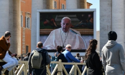 Personas observan la transmisión del mensaje del papa Francisco. | AFP