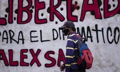 Una persona pasa delante de un grafiti que pide la liberación de Álex Saab.