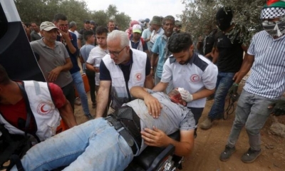 Los palestinos evacuan una persona herida durante los enfrentamientos con las tropas israelíes. | EFE