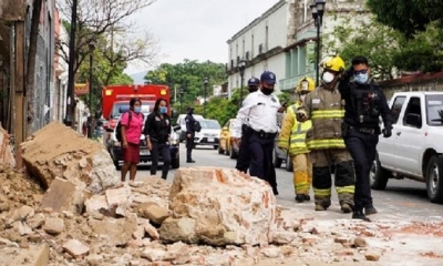 Miembros de la policía y de los bomberos observan los daños causados en una barda derrumbada este martes, en la ciudad de Oaxaca (México). 