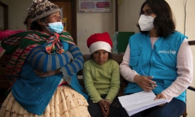 Una mamá escucha una orientación sobre salud mental de parte de un personal de UNICEF.