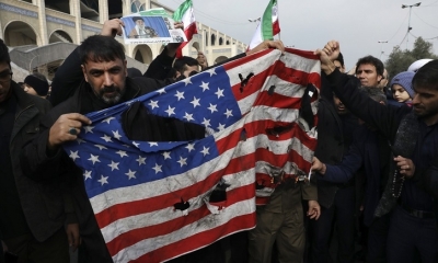 Manifestantes muestran una bandera de EE.UU. rota durante una protesta por el asesinato del general iraní Qassem Soleimani.