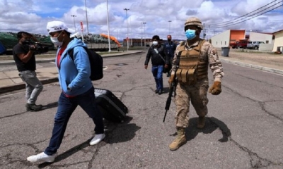 Un soldado chileno escolta a un migrante en Colchane en la frontera de Chile con Bolivia.