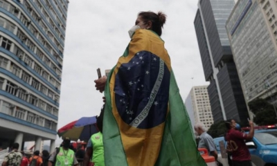 Una mujer arropada en una bandera brasileña participa en las marchas a favor y en contra del presidente de Brasil, Jair Bolsonaro. | EFE