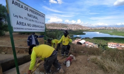 Funcionarios de Medio Ambiente ponen letreros de advertencia de la prohibición de venta de terrenos en San Pedro. 
