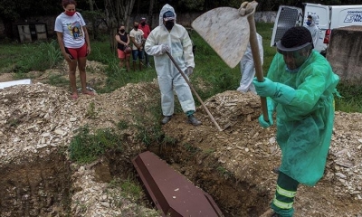 Fotografía tomada con dron que muestra familiares mientras observan hoy el entierro de un joven de 28 años muerto por coronavirus | EFE