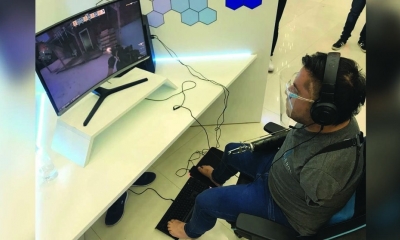 Jorge Coca juega usando el teclado de la computadora con los pies, en la Feria. KAREN CARRILLO