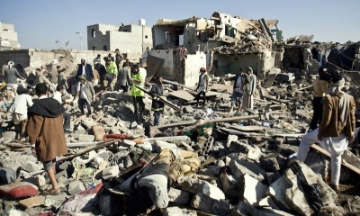 Un grupo de personas revisan los escombros provocados por la guerra en Yemen.