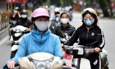 Motociclistas con mascarillas en una calle de Hanoi, Vietnam. | Fuente: AFP