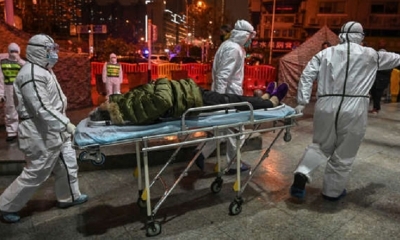 Personal médico llega con un paciente al Hospital de la Cruz Roja de Wuhan. | Fuente: AFP 