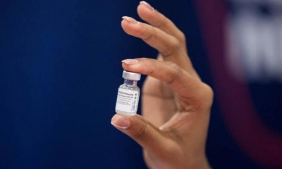 Una mujer sostiene un frasco de la vacuna Pfizer contra la Covid-19. | EFE