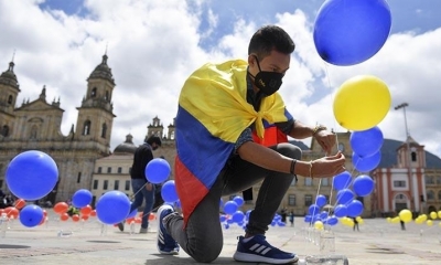 Un hombre coloca globos con los colores de Colombia. | AFP