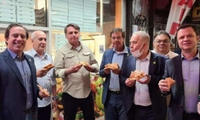 El presidente Bolsonaro (centro) y sus ministros comen pizza en una calle de Nueva York.