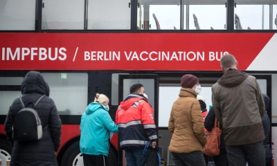 Varias personas esperan frente a un punto de vacunación en Berlín (Alemania)